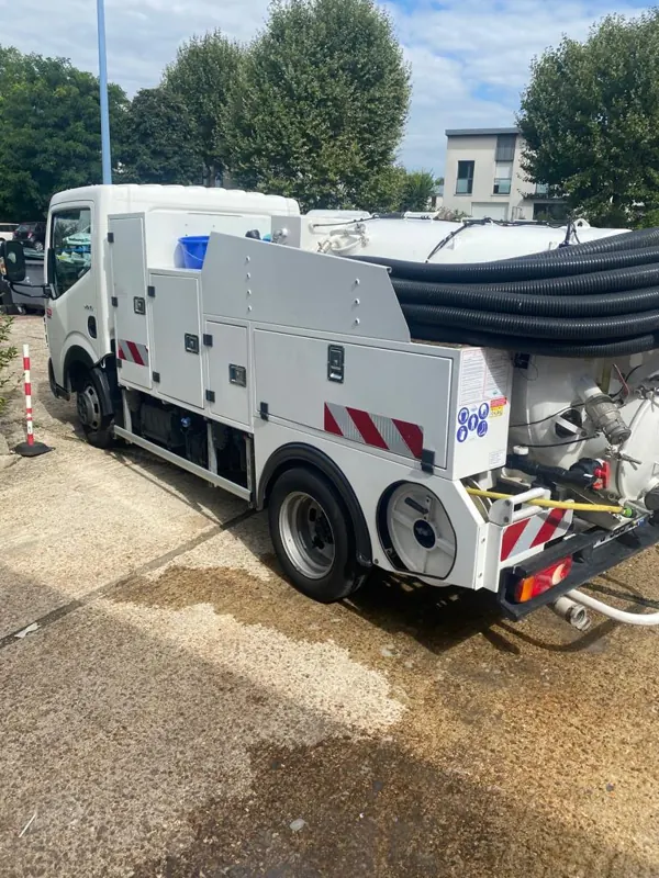 Camion hydrocureur haute pression avec sa cuve, ses flexibles et son enrouleur