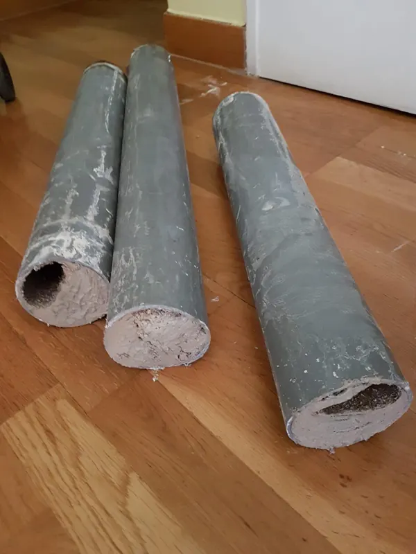 Tronçons de canalisation PVC coupés, section presque fermée par le tartre