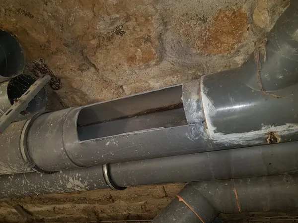 Collecteur en PVC ouvert dans une cave, paroi propre après curage