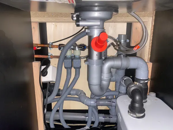 Siphon et évacuations sous un évier de cuisine